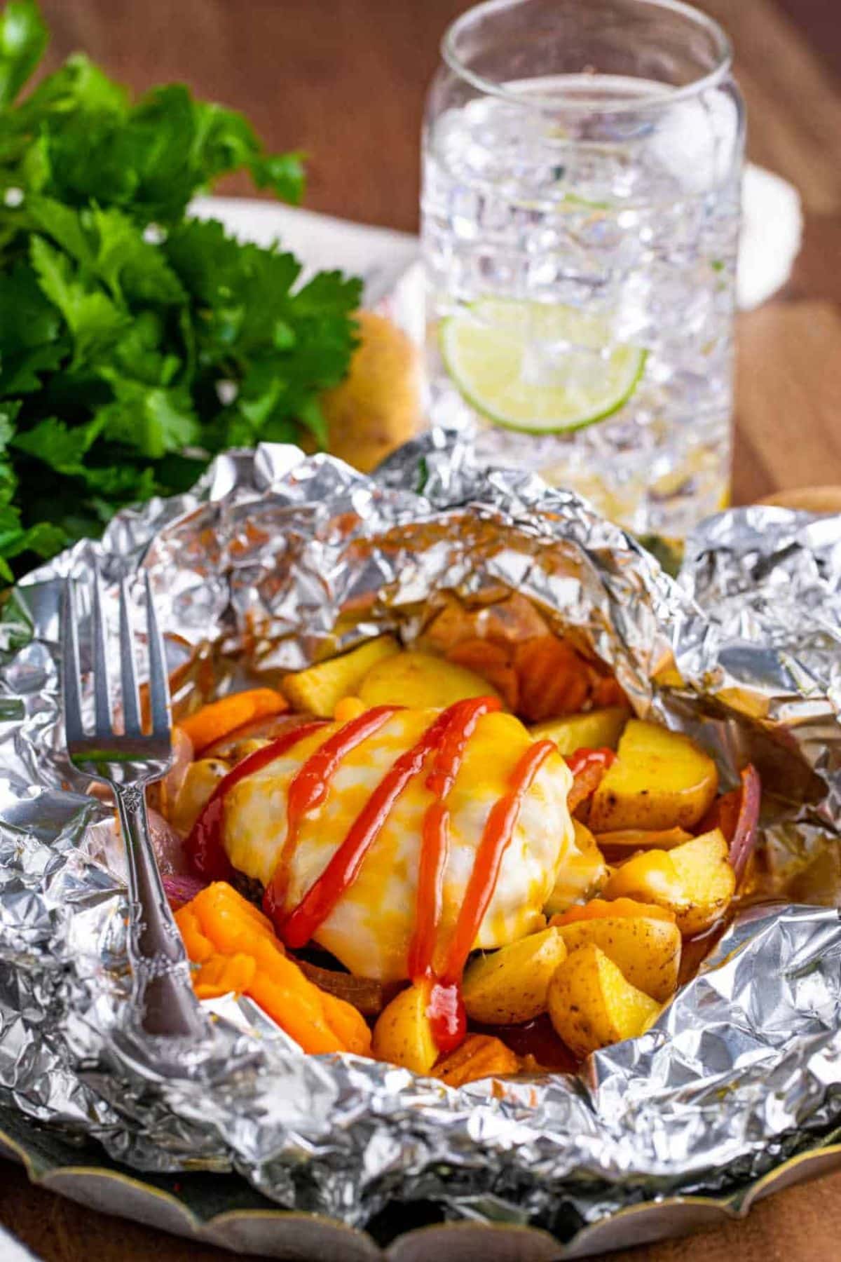 Burger patty and potatoes in foil.