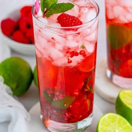Raspberry Mojitos with limes and raspberries around